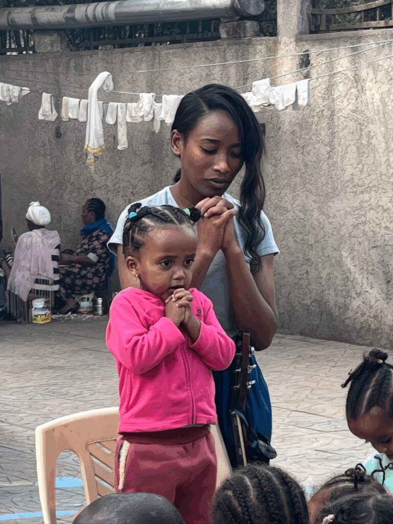 Ethiopian mother and daughter praying together in the Korah community of Addis Ababa